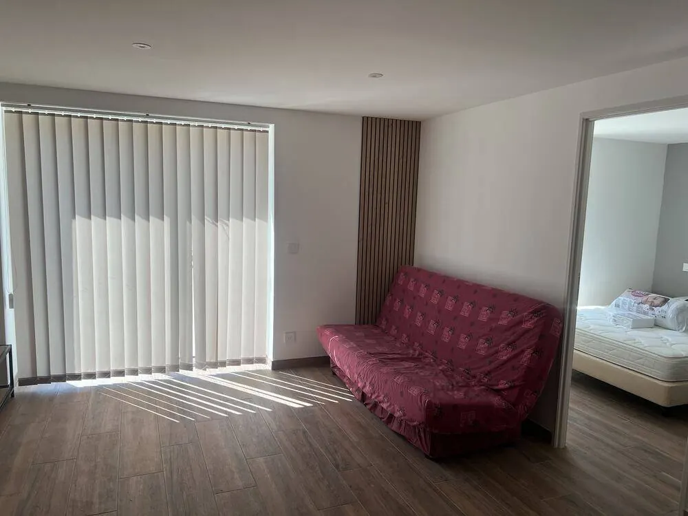 Après travaux : séjour avec sol carrelé effet bois et accès chambre