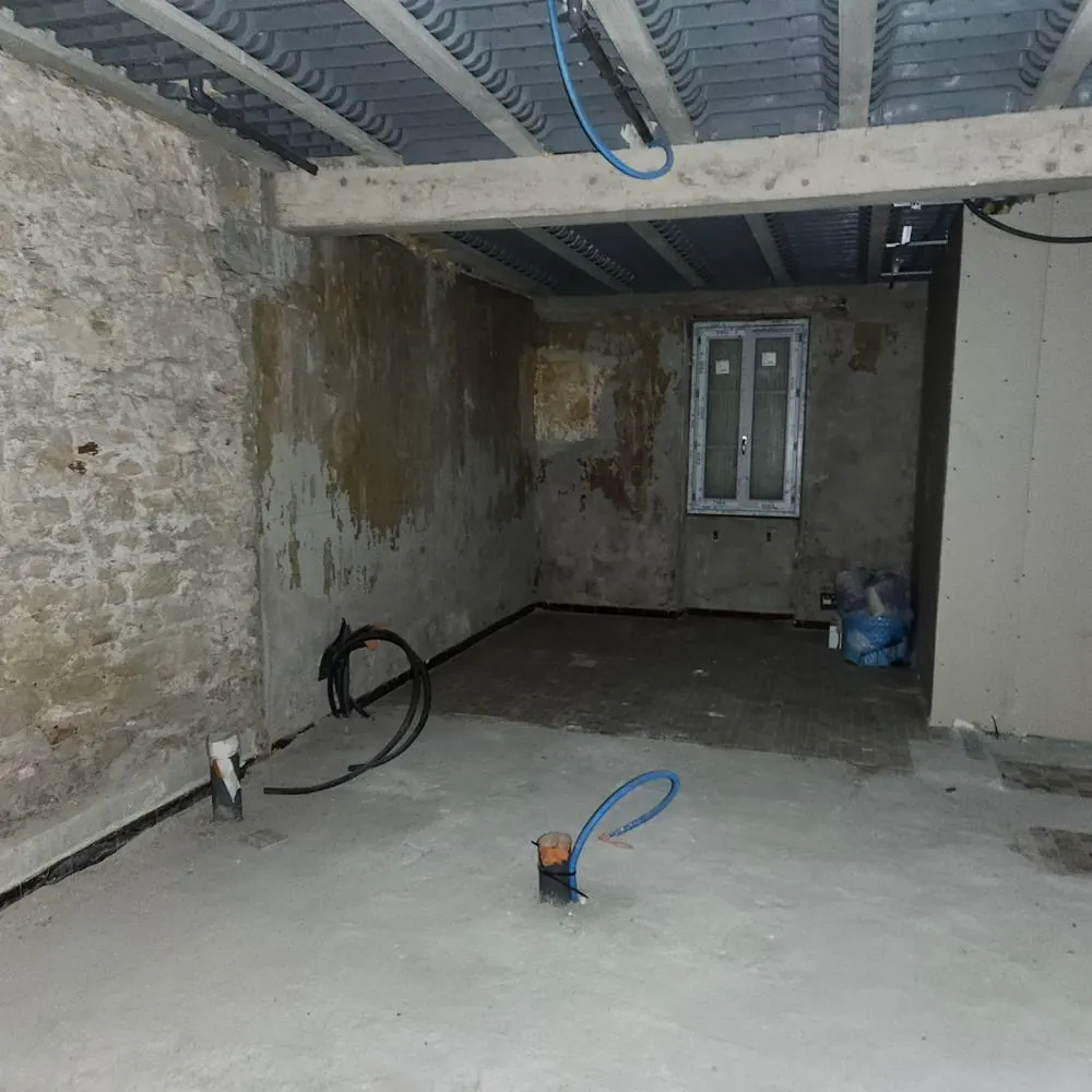 Avant travaux : pièce vide avec nouvelle fenêtre posée et réseaux en attente