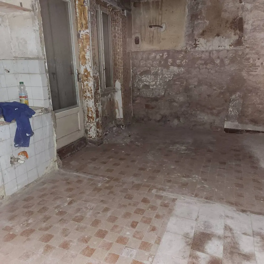 Avant travaux : sol en carrelage ancien et murs à nu